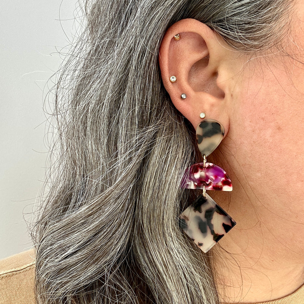 woman wearing a Acrylic Hemisphere drop earrings in black, white, pink and red