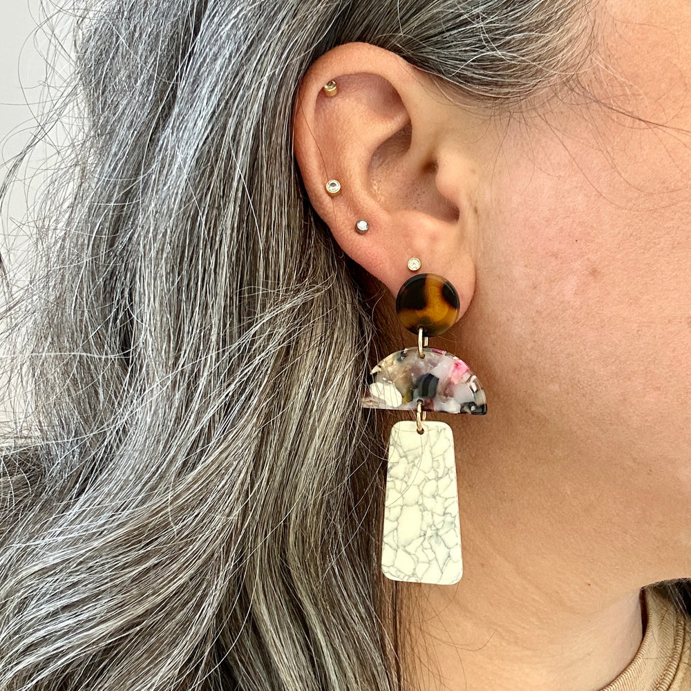 woman wearing a Acrylic Hemisphere drop earrings in multicolor, black, brown, pink and gray