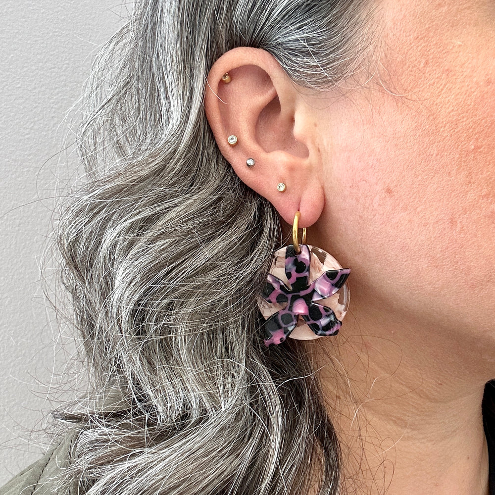 woman wearing Acrylic convertible hoop earrings in a mix of black and pink