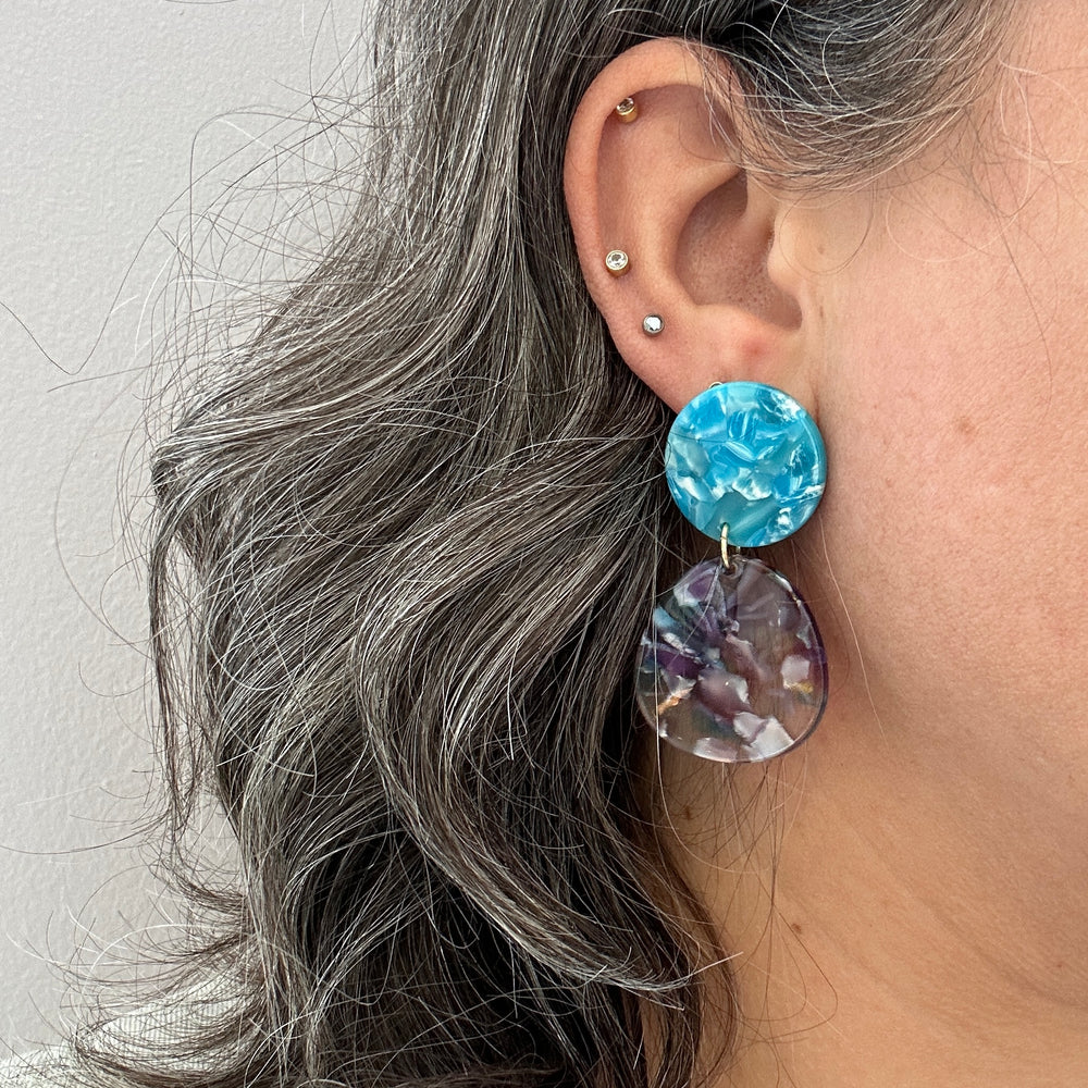 woman wearing a acrylic organic circle drop earring in purple and blue 