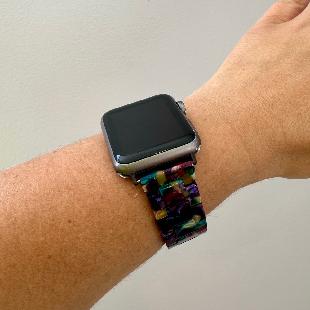 woman wearing acrylic Apple watch band in dark multicolor teal green purple navy blue golden yellow magenta pink