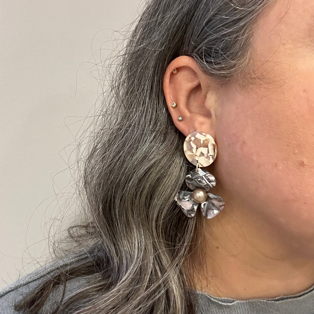 woman wearing acrylic Flower Drop Earrings in light pink and gray