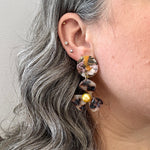 woman wearing acrylic Flower Drop Earrings in orange, pink and blonde tortoise