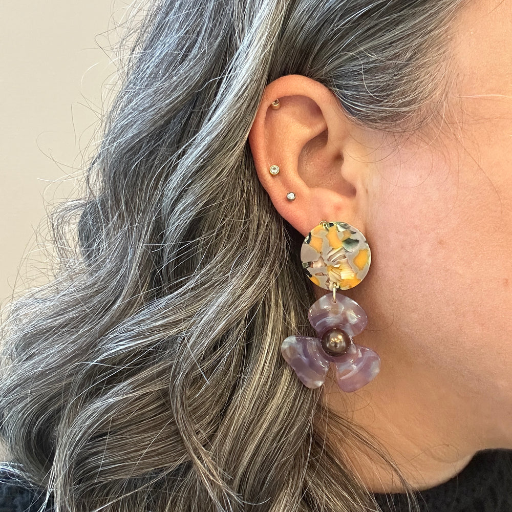 woman wearing acrylic Flower Drop Earrings in yellow, green and purple