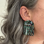 woman wearing acrylic Fringe Earrings in green, black and brown