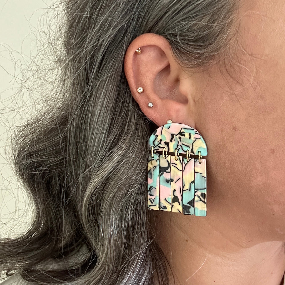 woman wearing acrylic Fringe Earrings in pastel pink, green, yellow and black