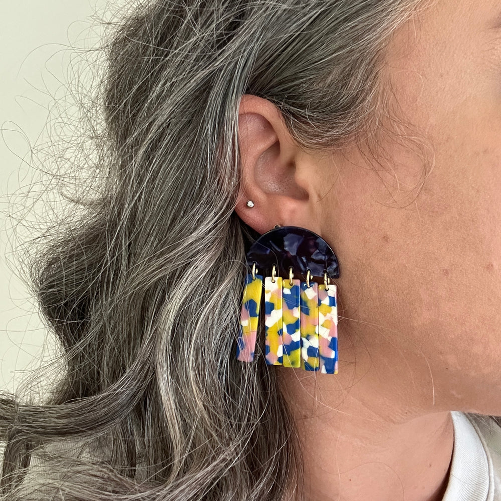 woman wearing acrylic Fringe Earrings in pink, blue, yellow and white