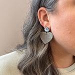 woman wearing acrylic Heart Earrings in Steel In Love and gray 