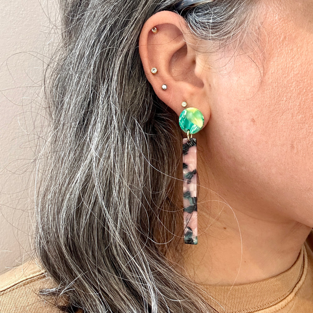 woman wearing acrylic Matchstick Drop Earrings in Tickled Pink with Envy pink, green and black