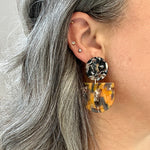 woman wearing acrylic Tab Drop Earrings in orange, black and gray