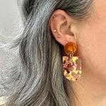 woman wearing acrylic Tab Drop Earrings in pink and yellow