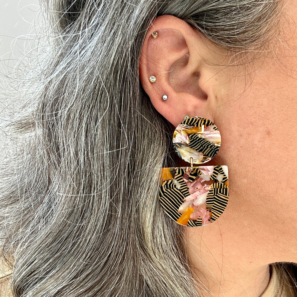 woman wearing acrylic Tab Drop Earrings in pink, orange and black