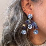 woman wearing acrylic arch drop earrings in blue