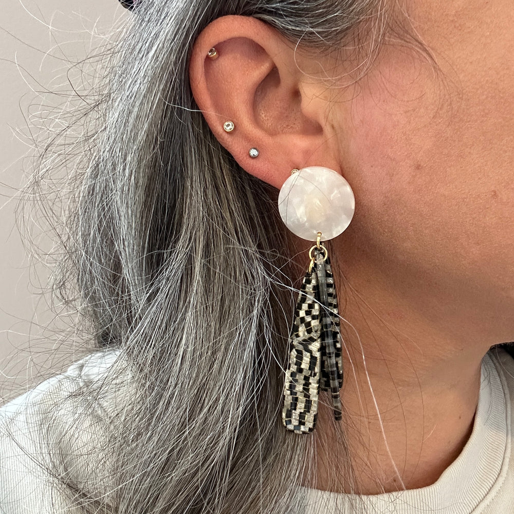 woman wearing acrylic flower Petal Drop Earrings in black and white checker