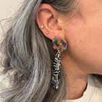 woman wearing acrylic flower Petal Drop Earrings in black and white stripe with blue, yellow and pink