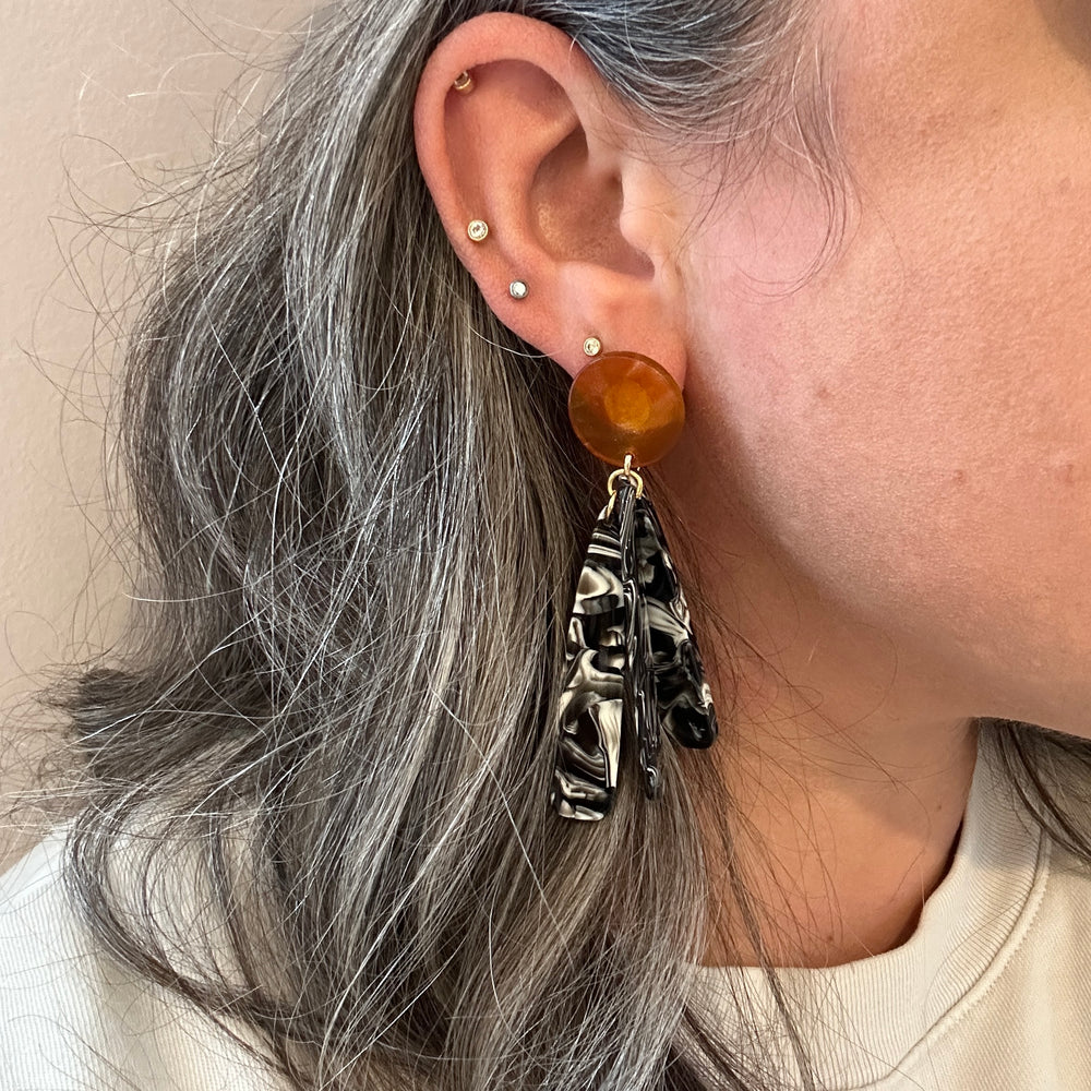 woman wearing acrylic flower Petal Drop Earrings in black, brown and white