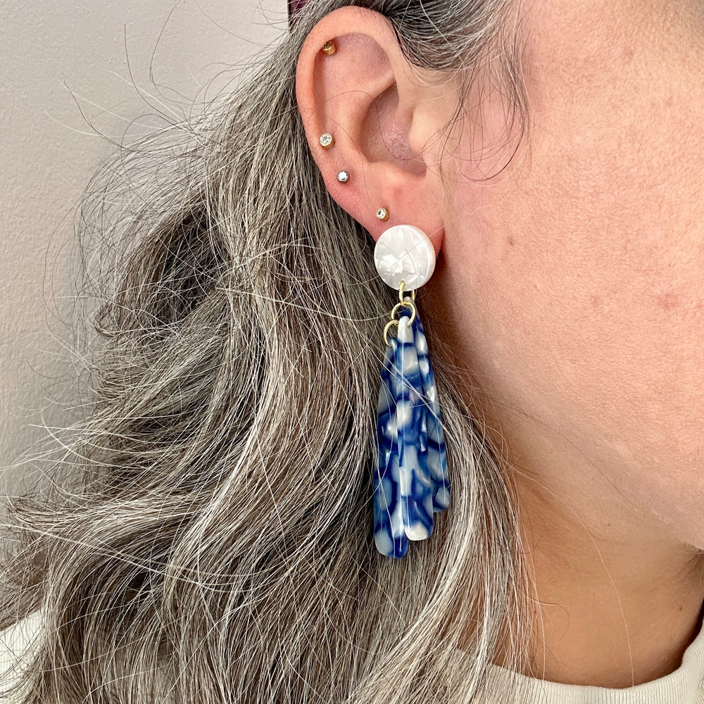 woman wearing acrylic flower Petal Drop Earrings in blue and white