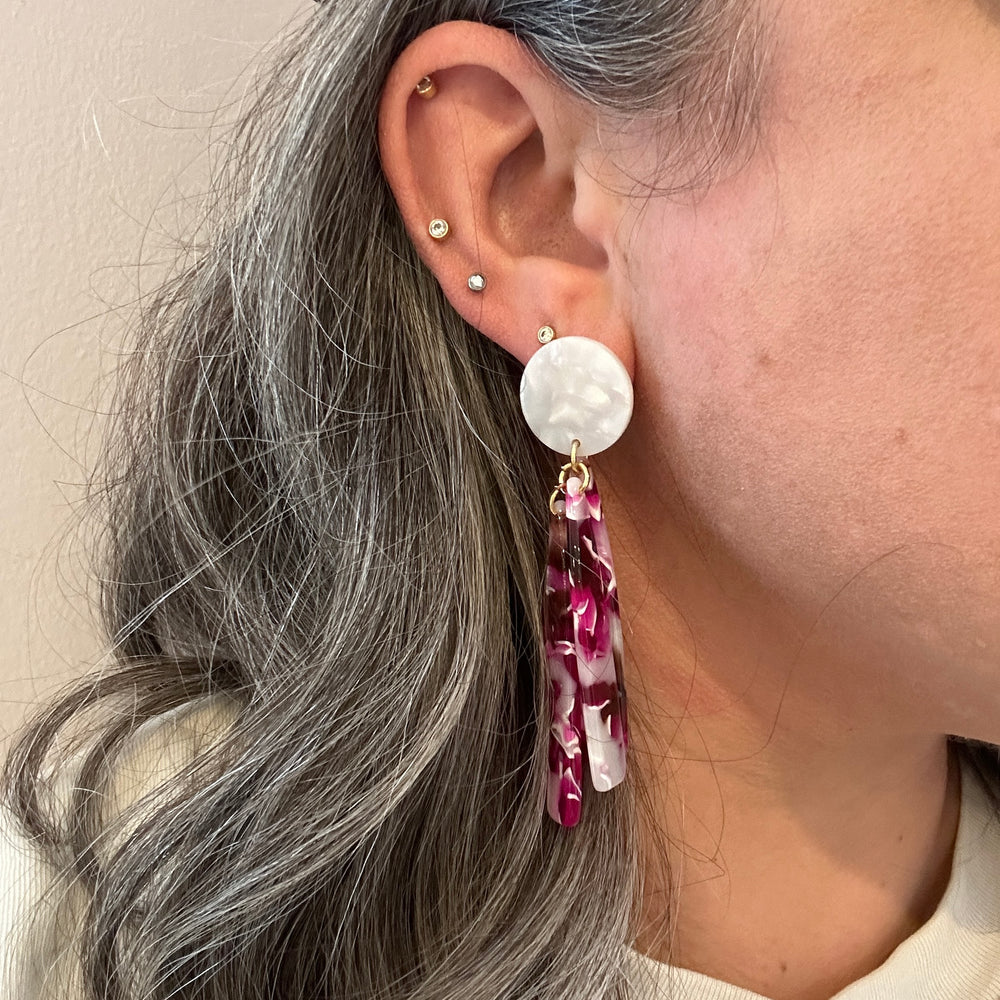 woman wearing acrylic flower Petal Drop Earrings in fuchsia and white