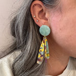 woman wearing acrylic flower Petal Drop Earrings in green, yellow and purple