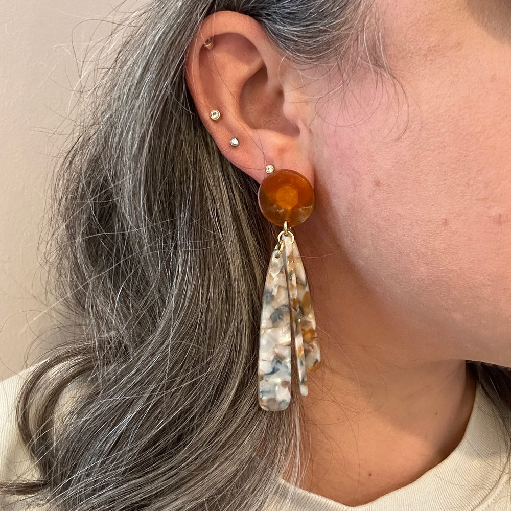 woman wearing acrylic flower Petal Drop Earrings in orange, blue and white