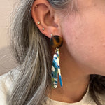 woman wearing acrylic flower Petal Drop Earrings in pink, white, green and blue with tortoise