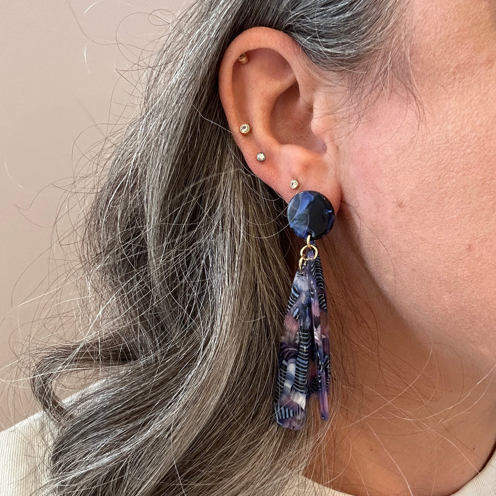 woman wearing acrylic flower Petal Drop Earrings in purple, pink and blue