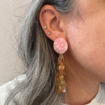 woman wearing acrylic flower Petal Drop Earrings in yellow, pink and brown