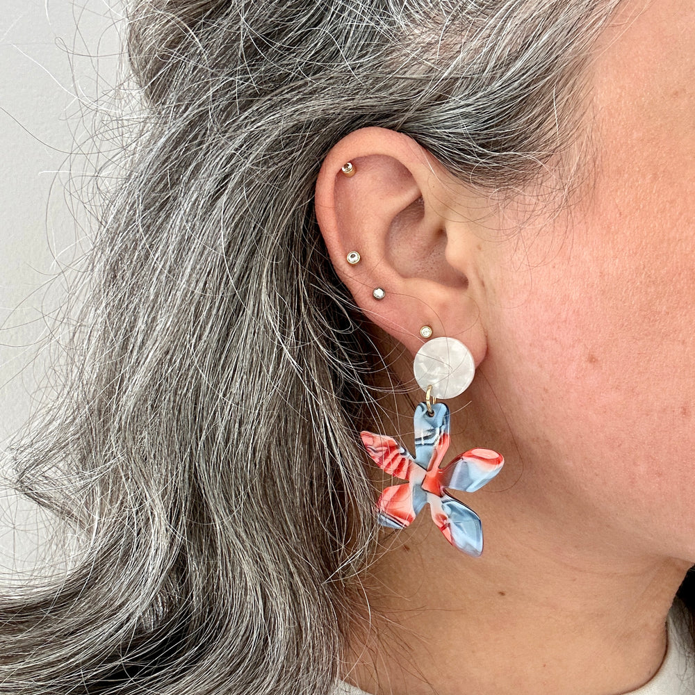 woman wearing acrylic flower earrings in freedom red, white and blue