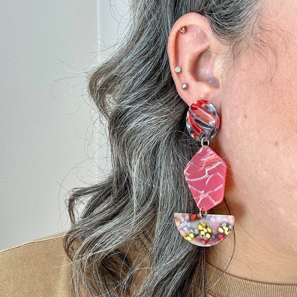 woman wearing an acrylic Pendulum Drop Earrings in Love Yourself To Peaces, red, yellow and blue 