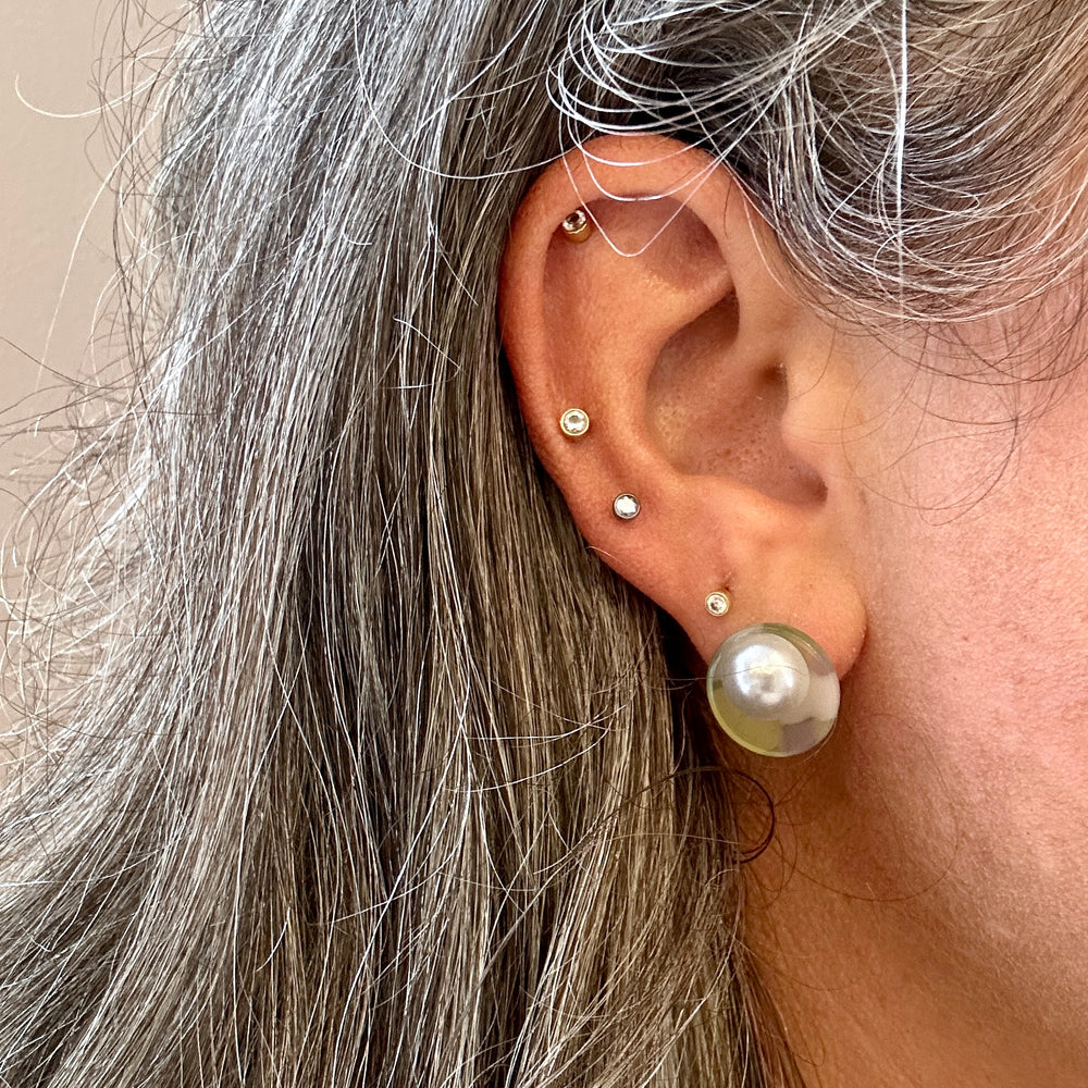 woman wearing an acrylic stud earring in mix of purple, gray, green and yellow 