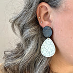 women wearing acrylic teardrop earrings in white, gray, and black 