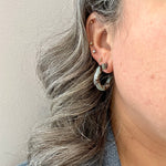 Woman wearing  Mini acrylic hoop earrings in grey and blue