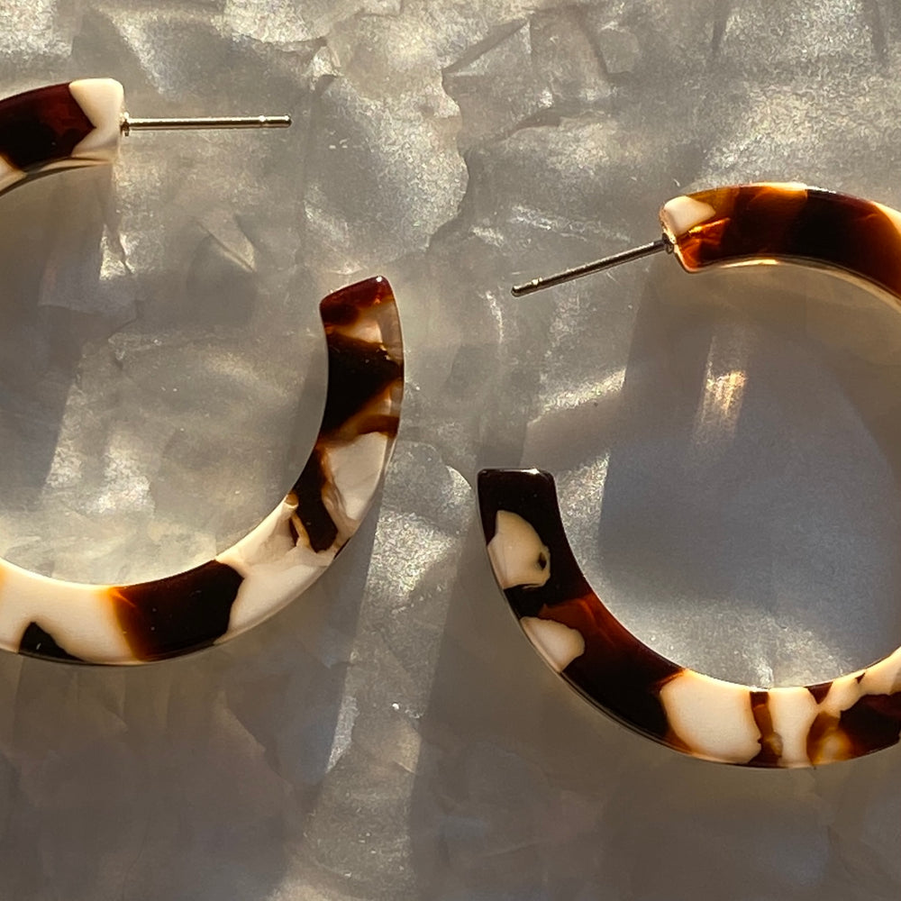 Woman wearing Acrylic Hoop Earrings in cream and brown