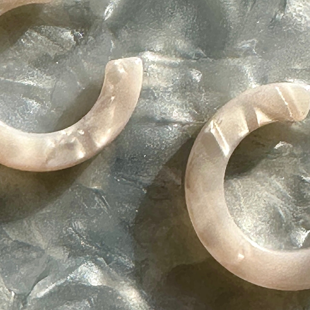 Close up of mini acrylic hoop earring in white 