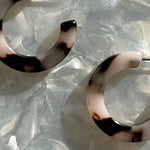 close up of Mini acrylic hoop earrings in black and white 