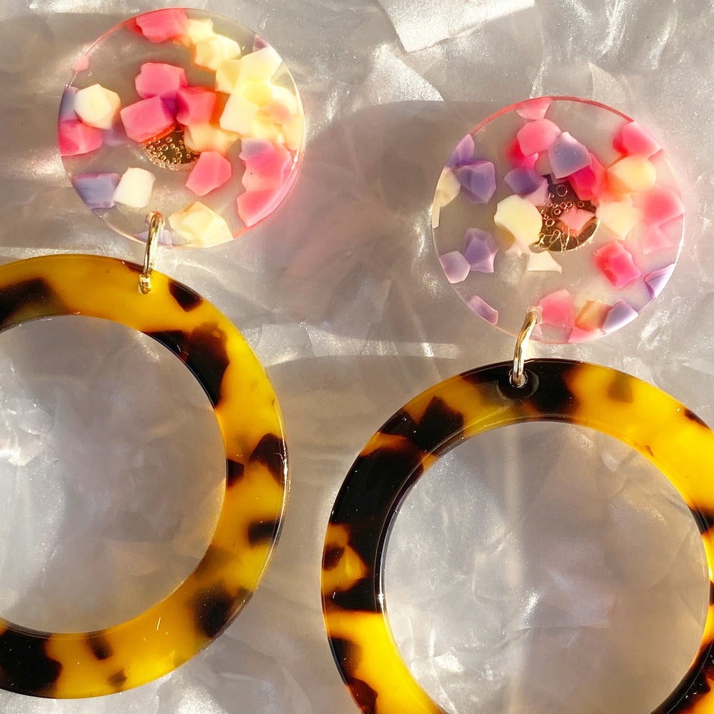 woman wearing acrylic open circle drop earring in Tortoise, yellow, pink and purple