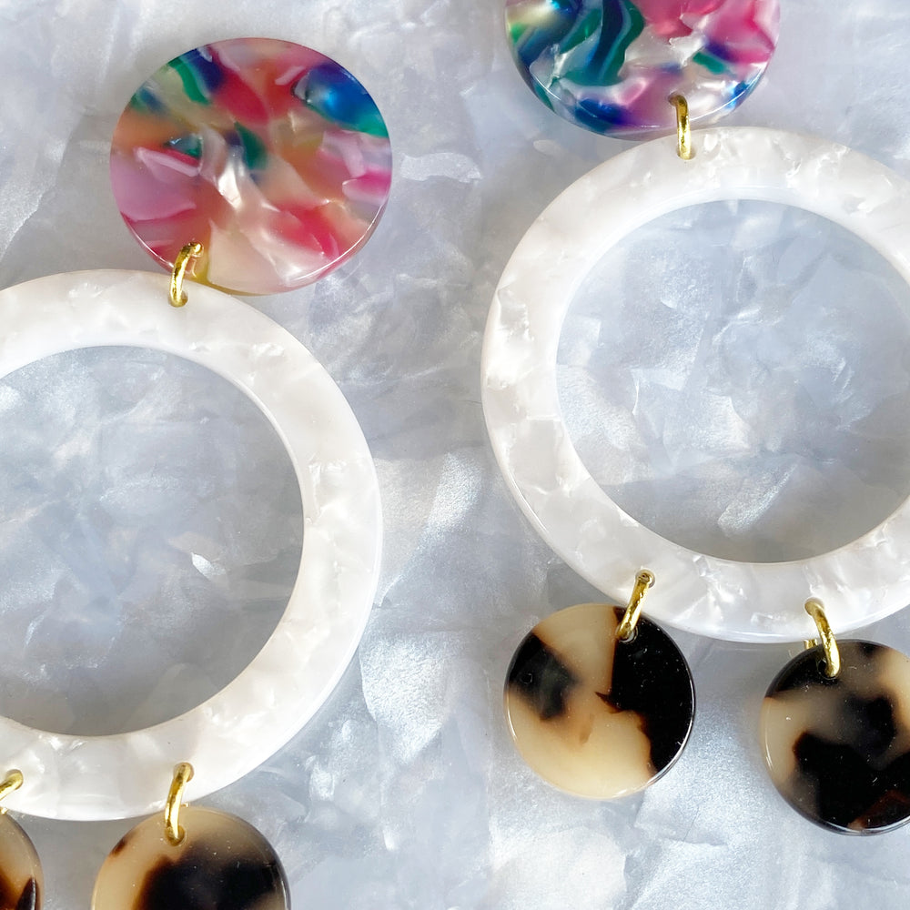 woman wearing acrylic open circle drop earring in multicolor, white, and blonde Tortoise 