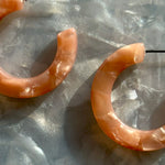 woman wearing mini acrylic hoop earrings in pink